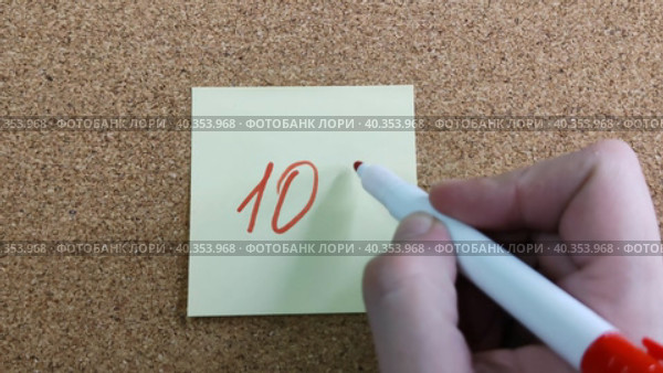 Девушка пишет надпись 10% красным маркером на желтом бумажном стикере, приклеенном к пробковой доске. Женская рука с цветным фломастером. Рукописный текст красивым почерком. Процент скидки, убытка или прибыли. Girl writes the inscription 10% with red marker on yellow paper sticker glued to cork board. Woman hand with colored felt-tip pen. Handwritten text in beautiful handwriting. Percentage of discount, loss or profit. Стоковое видео, видеограф Ирина / Фотобанк Лори