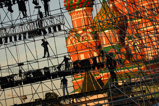 Diagonal view on workers on stage construction levels at Moscow Red Square in front of Vasiliy Blazhenniy Cathedral. Workers shadow figures on staging construction. Pop music stage under construction (2005 год). Редакционное фото, фотограф Mikhail Leonov / Фотобанк Лори