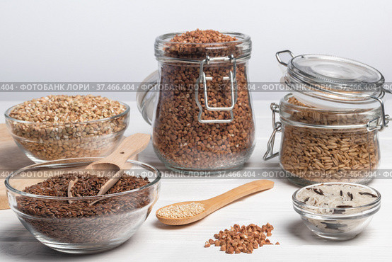Different cereals on white wooden table. Buckwheat, green buckwheat, whole grain oat, rice, flax seed and quinoa. Horizontal orientation. Стоковое фото, фотограф Алдошина Екатерина / Фотобанк Лори