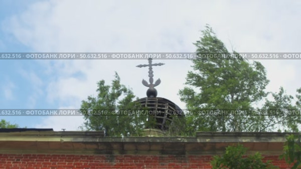 Dilapidated onion-shaped dome, embellished with Orthodox cross, dominates a brick church, now enveloped in foliage. Стоковое видео, видеограф Strunov David / Фотобанк Лори