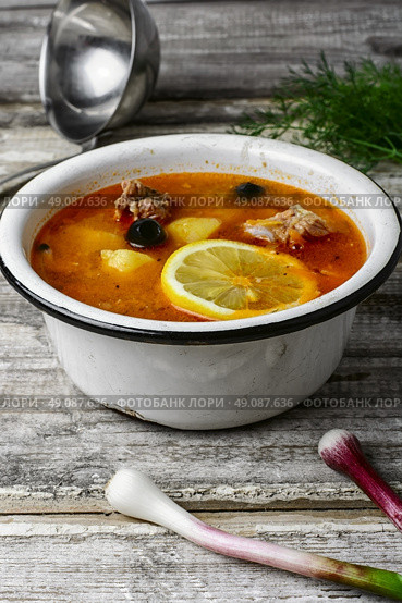 Dish of Russian cuisine-beef stew. Traditional solyanka with smoked meat products in the iron bowl. Стоковое фото, агентство Ingram Publishing / Фотобанк Лори