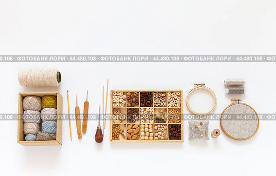 DIY concept. Natural materials for craft or needlework. Accessories for crochet and hand embroidery: hoops, set of cotton yarn, crochet hooks, box with wooden beads. Making handmade gifts. Copy space. Стоковое фото, фотограф Виктория Катьянова / Фотобанк Лори