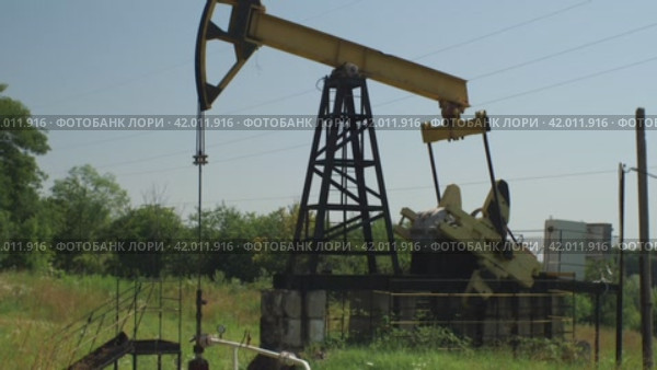 Добыча нефти. Нефтяная вышка добывает сырье на месторождении. Промышленное оборудование. Концепция нефтегазовой промышленности. Стоковое видео, видеограф Воловодов Владимир / Фотобанк Лори