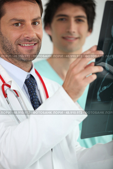 Doctor and nurse looking at X-ray. Стоковое фото, агентство Ingram Publishing / Фотобанк Лори