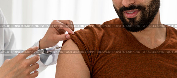 doctor vaccinating bearded man. Стоковое фото, агентство Ingram Publishing / Фотобанк Лори