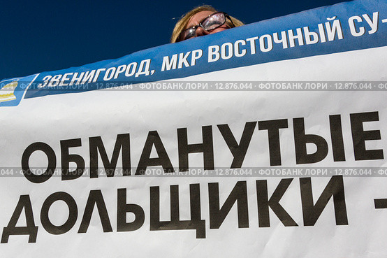 Дольщик строительной компании держит плакат митинге обманутых дольщиков компании СУ-155 в городе Москве, Россия (2015 год). Редакционное фото, фотограф Николай Винокуров / Фотобанк Лори