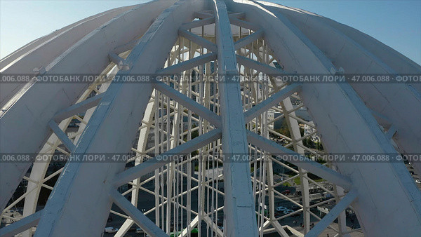 Dome made of metal semi-arches with air space on background of modern city. Стоковое фото, фотограф David Kashakhi / Фотобанк Лори