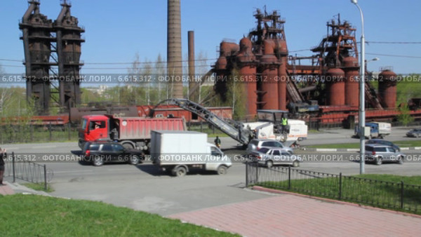 Дорожная фреза удаляет старый асфальт и с помощью транспортера сбрасывает в грузовик. Стоковое видео, видеограф Евгений Ткачёв / Фотобанк Лори