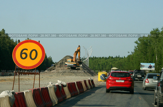 Дорожный знак «Ограничение максимальной скорости» - 60. Экскаватор Hyundai на большой куче гравия. Капитальный ремонт трассы "Крым" (Симферопольское шоссе), июль 2018. Редакционное фото, фотограф Щеголева Ольга / Фотобанк Лори