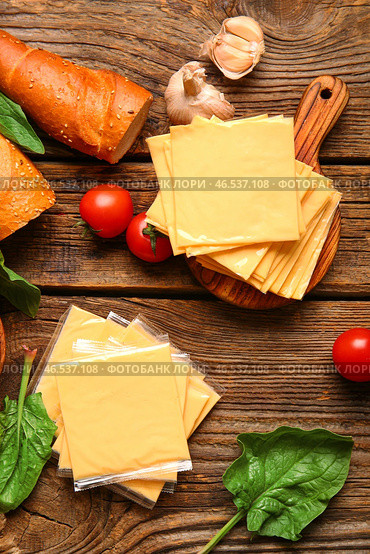 Доска с ломтиками вкусного обработанного сыра, хлебом и помидорами на деревянном фоне. Стоковое фото, фотограф Pixel_shot / Фотобанк Лори