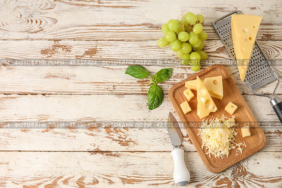 Доска с вкусным швейцарским сыром и виноградом на светлом деревянном фоне. Стоковое фото, фотограф Pixel_shot / Фотобанк Лори