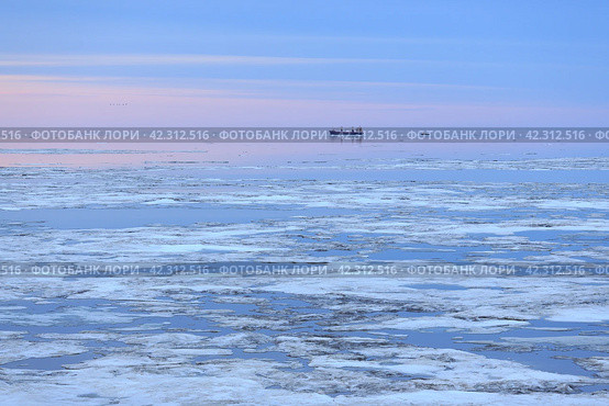 Доставка грузов и снабжение в Арктике. Морской арктический пейзаж с грузовым судном в море среди льдин. Морские грузоперевозки в сложной ледовой обстановке. Июнь на Крайнем Севере России. Анадырский залив, Берингово море, Тихий океан. Чукотка, Дальний Восток России. Стоковое фото, фотограф Андрей Степанов / Фотобанк Лори