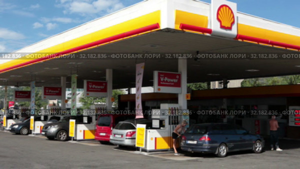 Drivers fill up their cars on the Shell petrol station in Stockholm city. Exterior of white and yellow building. Shell is largest oil company in the world. Sweden (2019 год). Редакционное видео, видеограф Кекяляйнен Андрей / Фотобанк Лори
