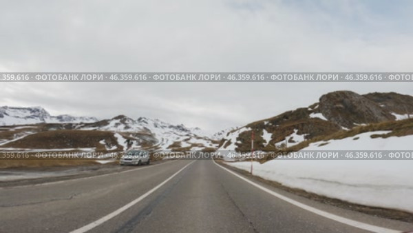 Driving on mountain road with snow patches in early spring. Стоковое видео, видеограф Данил Руденко / Фотобанк Лори