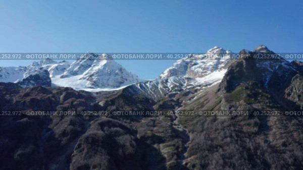 Drone flying along snow covered white mountain glacier in sunny autumn day. Стоковое видео, видеограф Кирилл Трифонов / Фотобанк Лори