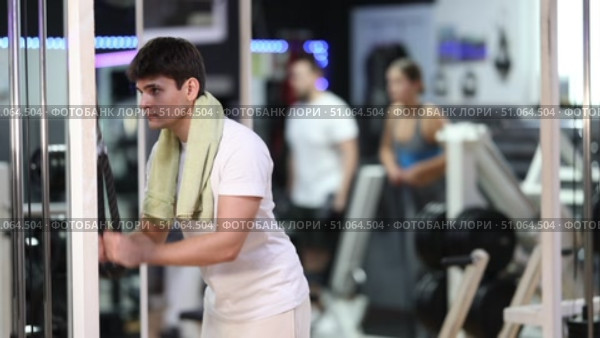 During workout, guy performs grueling exercises and pumps muscles of arm on crossover exercise machine. Sport club client participates in fitness marathon, works with muscles and endurance. Стоковое видео, видеограф Яков Филимонов / Фотобанк Лори