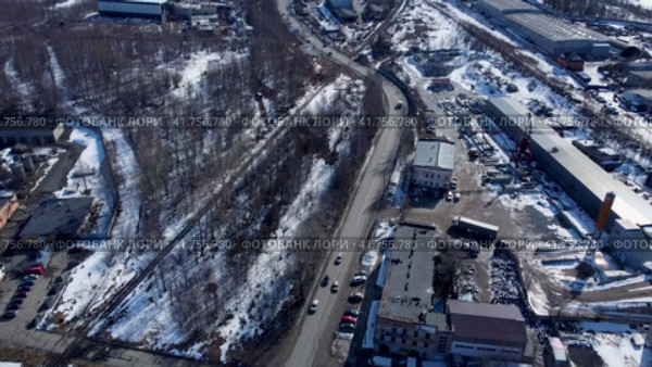 Движение машин весенним утром по дороге в городской промзоне в городе Петрозаводске. Аэросъемка, статичный вид (2023 год). Редакционное видео, видеограф Sergei Gorin / Фотобанк Лори