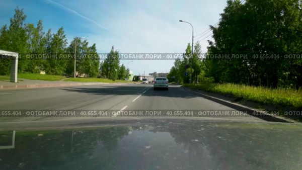 Движение машины мимо здания республиканской больницы им. В.А. Баранова в Петрозаводске солнечным утром летом. Вид от первого лица с капота машины (2023 год). Редакционное видео, видеограф Sergei Gorin / Фотобанк Лори