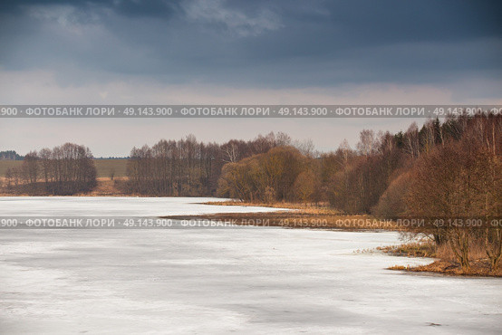 Early spring. Mud season. Lake under ice and snow melting. Cloudy spring day. Spring rural scene. Стоковое фото, агентство Ingram Publishing / Фотобанк Лори