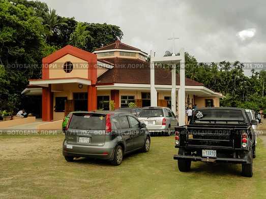 Echang, Palau - July 1, 2018. Parking in front of St. Joseph Church. Церковь Святого Иосифа в поселке Эанг, Республика Палау. Редакционное фото, фотограф Александр Кузнецов / Фотобанк Лори