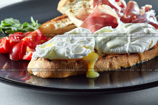 Egg benedict on toast with bacon and vegetables. Eggs benedict for breakfast. Стоковое фото, агентство Ingram Publishing / Фотобанк Лори