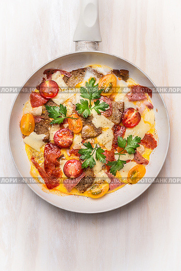 Egg omelette in white frypan with tomatoes,bread, cheese and sausage on white wooden background, top view, close up. Стоковое фото, агентство Ingram Publishing / Фотобанк Лори
