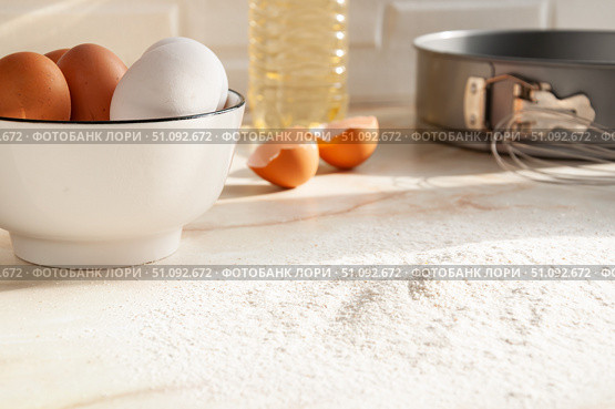 Eggs in a ceramic cup close-up. Cooking in the kitchen. White and brown eggs. Sunny morning. Backing. Selective focus. Стоковое фото, фотограф Анастасия  Гудантова / Фотобанк Лори