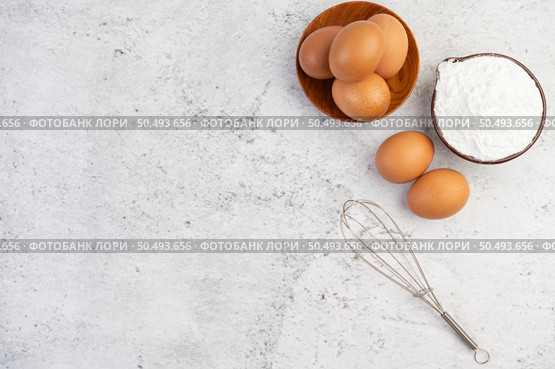 Eggs, tapioca flour in a cup and beat eggs on a white cement floor. Стоковое фото, агентство Ingram Publishing / Фотобанк Лори