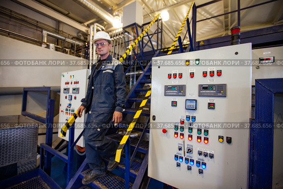 Ekibastuz, Kazakhstan - May 28, 2012. Explosive material production plant for coal quarry mining. Chemical engineer and equipment control panel. Focus on right panel. Редакционное фото, фотограф Alexey Rezvykh / Фотобанк Лори