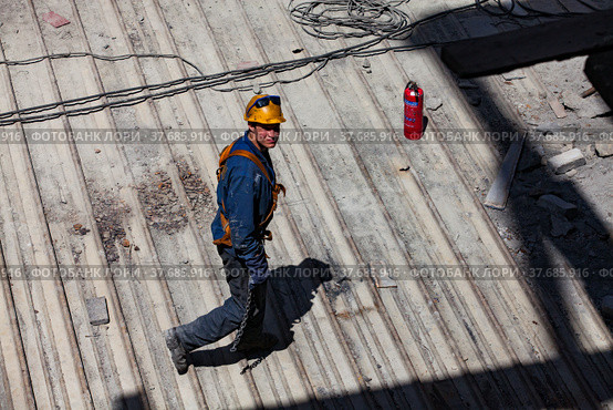 Ekibastuz, Pavlodar region, Kazakhstan - May 28, 2012: GRES-1 steam power station. Industrial climber (builder) and fire extinguisher on metal roof. Стоковое фото, фотограф Alexey Rezvykh / Фотобанк Лори