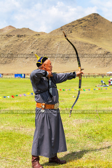 ELANTSY VILLAGE, IRKUTSK REGION, RUSSIA - July 5, 2025: Erdyn Games are festival of nomadic peoples of Eurasia. An archer in national costume competes in archery near sacred Mount Erd on Lake Baikal. Редакционное фото, фотограф Виктория Катьянова / Фотобанк Лори