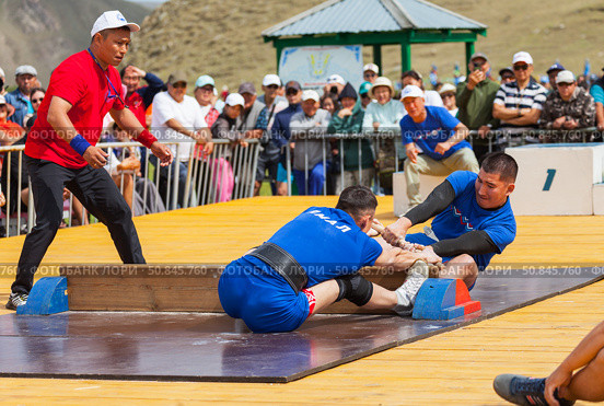 ELANTSY VILLAGE, IRKUTSK REGION, RUSSIA - July 5, 2025: Erdyn Games - festival of nomadic peoples of Eurasia. Wrestlers compete in mas-wrestling - a strength sport of pulling stick. Редакционное фото, фотограф Виктория Катьянова / Фотобанк Лори