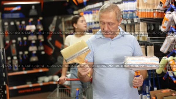 Elderly man choosing paint rollers and brushes. Стоковое видео, видеограф Яков Филимонов / Фотобанк Лори