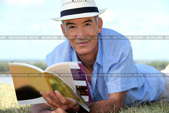 Elderly man reading a book outside. Стоковое фото, агентство Ingram Publishing / Фотобанк Лори