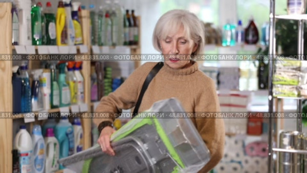 Elderly woman buys convenient lightweight ironing board at a hardware store. Стоковое видео, видеограф Яков Филимонов / Фотобанк Лори