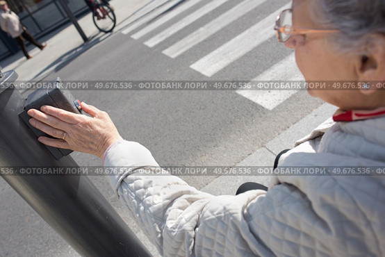 elderly woman pressing crosswalk button. Стоковое фото, агентство Ingram Publishing / Фотобанк Лори