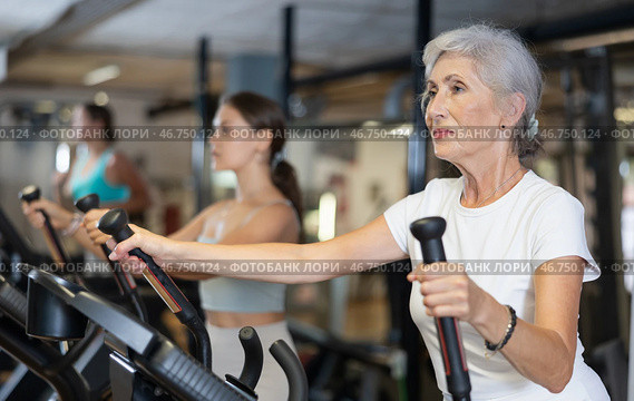 Elderly woman training on an elliptical machine. Стоковое фото, фотограф Яков Филимонов / Фотобанк Лори