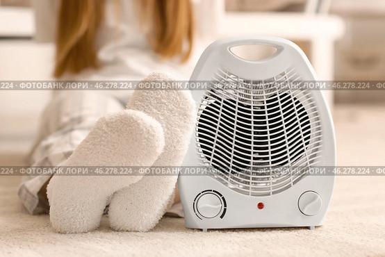 Electric fan heater and woman in warm socks on floor at home, closeup. Стоковое фото, фотограф Pixel_shot / Фотобанк Лори