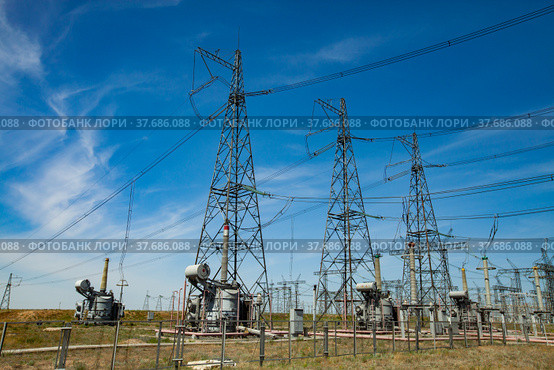 Electric transformer substation. Distribution station of electricity. Blue sky background. Стоковое фото, фотограф Alexey Rezvykh / Фотобанк Лори