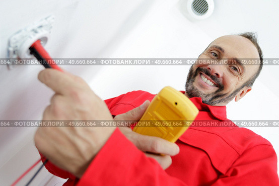 electrician assembles a standard bipolar wall socket. Стоковое фото, агентство Ingram Publishing / Фотобанк Лори