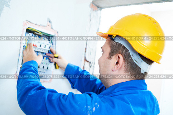 electrician installing switching electric actuator in fuse box. Стоковое фото, фотограф Дмитрий Калиновский / Фотобанк Лори