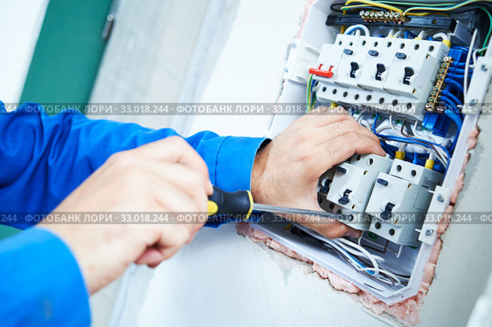 Electrician works with scredrivew in switchbox. current breaker installation. Стоковое фото, фотограф Дмитрий Калиновский / Фотобанк Лори