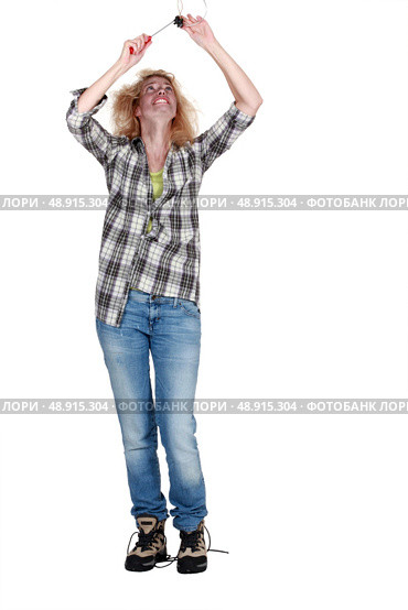 Electrocuted woman mending a ceiling light. Стоковое фото, агентство Ingram Publishing / Фотобанк Лори