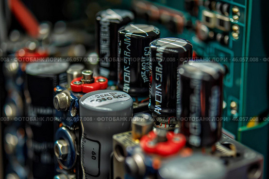 Electrolytic capacitors standing on circuit board in row. Стоковое AI-изображение, AI-художник Иван Рябоконь / Фотобанк Лори