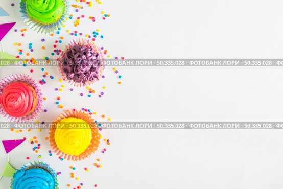 elevated view colorful muffins bunting white surface. Стоковое фото, агентство Ingram Publishing / Фотобанк Лори