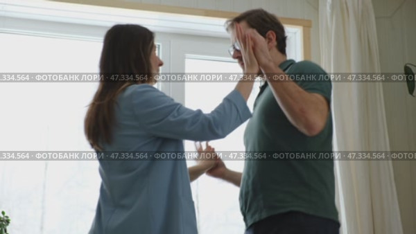 Emotional Dance. Middle-aged Couple Dancing Together Embrace at Home. Mature Couple dancing bonding, smiling and moving to the rhythm in a romantic vibe enjoying their anniversary. Active relationship. Стоковое видео, видеограф Марина Демидюк / Фотобанк Лори