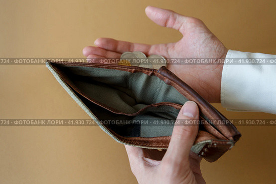 Empty wallet in the hands of a man on a plain background. Стоковое фото, фотограф Aleksandra Selivanova / Фотобанк Лори