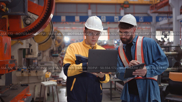 Engineer and technician discussing machinery in factory to plan inspection maintenance according to usage cycle, Concepts inspections based on usage cycle maintenance. Стоковое фото, агентство Ingram Publishing / Фотобанк Лори