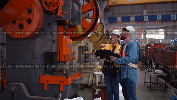 Engineer and technician discussing machinery in factory to plan inspection maintenance according to usage cycle, Concepts inspections based on usage cycle maintenance. Стоковое фото, агентство Ingram Publishing / Фотобанк Лори
