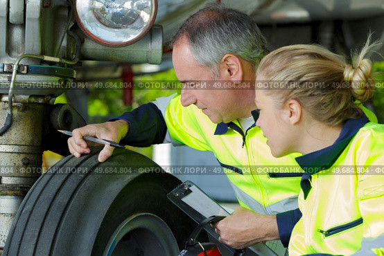 engineer checking tread on aircraft landing gear. Стоковое фото, агентство Ingram Publishing / Фотобанк Лори